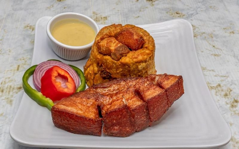 Experience the heart of Dominican cuisine with our delicious Mofongo, made from scratch with chicharrón and a heavenly garlic sauce—order now and treat yourself to a taste sensation!
